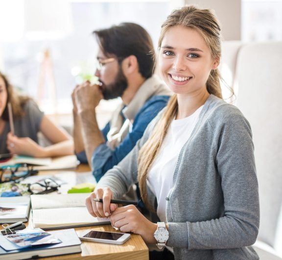 Happy young specialist looking at camera during work